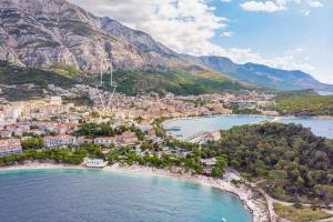 an aerial view of a beach with mountains in the background at Villa Filipetti in Makarska center, 4 en-suite bedrooms charming stone house, heated private pool, 600m from beach in Makarska