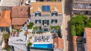 an aerial view of a building with a swimming pool at Villa Filipetti in Makarska center, 4 en-suite bedrooms charming stone house, heated private pool, 600m from beach in Makarska
