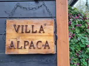 a sign that says villa alzona hanging on a wall at Villa Alpaca Mökki - Laamatila in Nokia