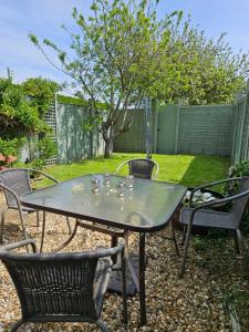 a patio table and chairs with glasses on it at Rosehip Cottage in Somerton +10 photos