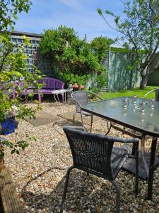 a patio with a table and chairs in a garden at Rosehip Cottage in Somerton