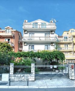 un edificio blanco alto con una valla delante en Sun Guest House, en Budva