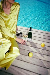 a woman in a yellow dress sitting next to a bottle of wine at Hotel KÜGLERHOF in Tirolo