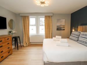 sypialnia z dużym białym łóżkiem i oknem w obiekcie Carrawburgh Suite w mieście Hexham