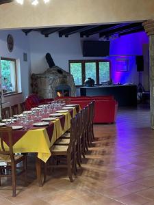 una sala da pranzo con un lungo tavolo e bicchieri da vino di Agriturismo Tre Elle ad Acri
