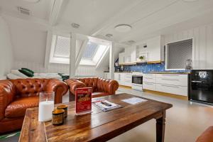 ein Wohnzimmer mit einem Ledersofa und einem Tisch in der Unterkunft Fengselshotellet AS in Arendal