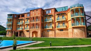 a building with a swimming pool in front of it at Burki Castle & Cellar in Kvareli