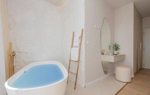 ein Badezimmer mit einer weißen Badewanne und einem Spiegel in der Unterkunft Villa Rosemary 2 in Makarska