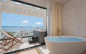 ein Bad mit einer Badewanne und einem großen Fenster in der Unterkunft Villa Rosemary 2 in Makarska