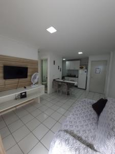 1 dormitorio con 1 cama y TV y cocina en Apartamento Top a Beira-Mar na Pajuçara - Maceió, en Maceió