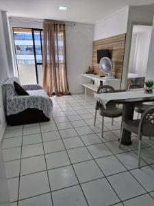 sala de estar con suelo de baldosa, mesa y sillas en Apartamento Top a Beira-Mar na Pajuçara - Maceió, en Maceió