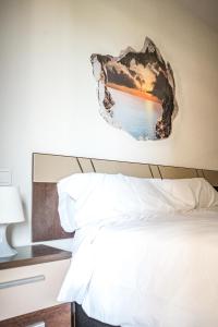 1 dormitorio con 1 cama con una foto en la pared en Cómodo apartamento en Tres Cantos by beBalmy en Tres Cantos