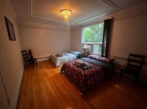 een slaapkamer met een bed en een bed en een raam bij Cozy 2 Bedroom in Montreal