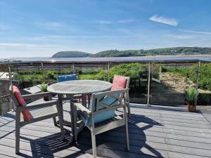 una mesa y sillas en una terraza con vistas en Stunning 2-Bed House in Ferryside, en Ferryside