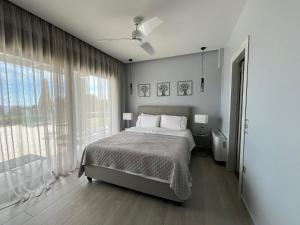 sypialnia z łóżkiem i dużym oknem w obiekcie Avithos Blue Villas w mieście Svoronata +37 zdjęć