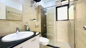 a bathroom with a sink and a glass shower at BluO Stylish 2BHK New Town Rajarhat - Skyline View Condo in Kolkata