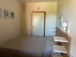 a bedroom with a bed and a door to a room at Casa azzurra Salina Bamba in Punta Molara