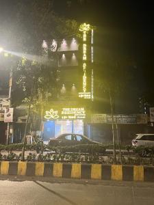 New Dream Residency By Glitz Hotels في مومباي: سيارة متوقفة أمام مبنى في الليل