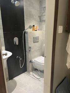 e bagno con doccia, servizi igienici e lavandino. di New Dream Residency By Glitz Hotels a Mumbai
