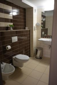 uma casa de banho com um WC e um lavatório em Black Tulip Hotel em Dej