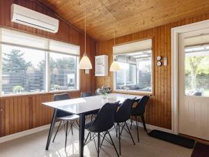 a dining room with a table and chairs and windows at 6 person holiday home in Hadsund in Nørre Hurup