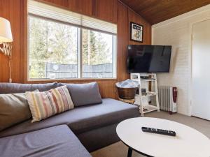 a living room with a couch and a tv at 6 person holiday home in Hadsund in Nørre Hurup