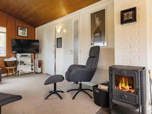 a living room with a chair and a fireplace at 6 person holiday home in Hadsund in Nørre Hurup