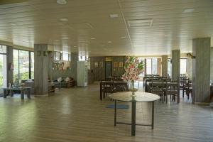 德拉敦Haut Monde Hill Stream Resort and Spa的大房间设有桌椅和鲜花桌