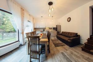 a kitchen and living room with a table and a couch at Căsuța din vis-Voroneț in Gura Humorului +13 photos