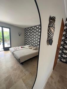 a bedroom with a bed and a mirror on the wall at Les Iris Villa Piscine chauffée 6 pers in Moissac-Bellevue
