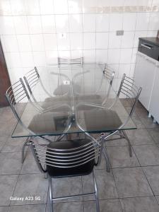 a glass table and chairs sitting on a tiled floor at Pousada Cabreúva in Cabreúva