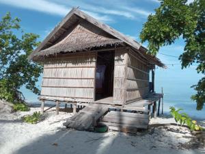 une cabane sur la plage avec l'océan en arrière-plan dans l'établissement West Mansuar Homestay, à Pulau Mansuar