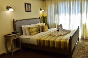 Hotel Polo Towers Shillong في شيلونغ: غرفة نوم بسرير وبطانية مخططة صفراء وبيضاء