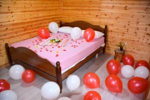 a room with a bed with red and white balloons at Eagles Land in Shkodër