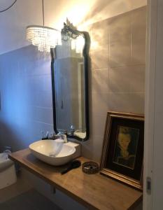 a bathroom with a sink and a mirror and a picture at A casa di Daniela in Massa Marittima +14 photos