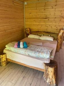 Cama en habitación de madera con sombreros y almohadas en Eagles Land en Shkodër