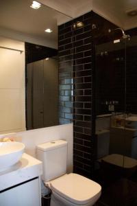 La salle de bains est pourvue de toilettes, d'un lavabo et d'une douche. dans l'établissement Multihouse Moderno Apartamento na Av. Paulista, à São Paulo