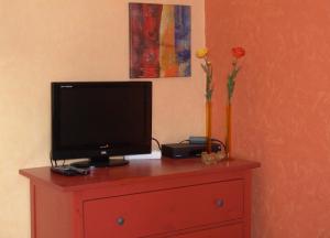 BeltheimにあるFerienhäuser MIA Am Baybachtalの花瓶付きドレッサー上のテレビ