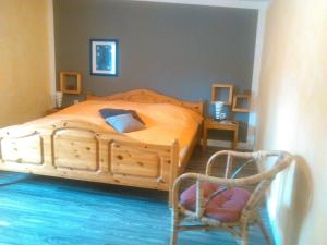 BeltheimにあるFerienhäuser MIA Am Baybachtalのベッドルーム(木製ベッド1台、椅子付) +13枚の写真