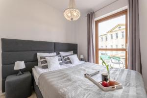 a bedroom with a bed with a bowl of fruit on it at Apartamenty Bałtyckie - Grand Baltic - WIFI, Klimatyzacja, Sala Zabaw, Taras wypoczynkowy, centrum Ustki in Ustka