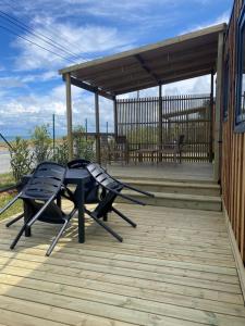 a patio with a table and chairs on a deck at Camping Ostréa **** in Dolus-d'Oléron