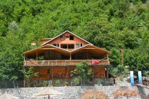 a large wooden house on the side of a mountain at Eagles Land in Shkodër