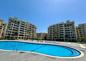 an empty swimming pool in front of two apartment buildings at Marina Views Al Hamra Village in Ras al Khaimah