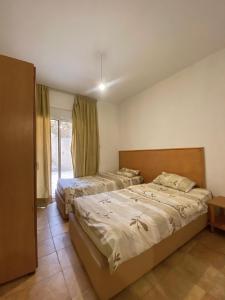 a bedroom with two beds and a window at Olympia in Kfardebian