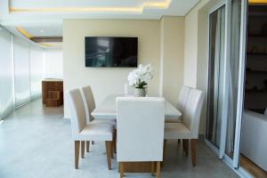 a white dining room with a white table and chairs at Multihouse Moderno Apartamento na Av. Paulista in Sao Paulo
