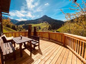 een houten terras met een tafel en een bank op een balkon bij Pointhütte in Grossarl