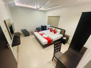 ChikodiHotel Ramdev Chikodi的房间里有一张床和一把椅子的卧室