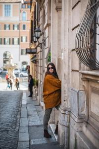 una mujer se apoya en un edificio en Parisii Luxury Relais Rome, en Roma