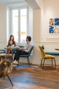 zwei Personen sitzen an einem Tisch in einem Zimmer in der Unterkunft Parisii Luxury Relais Rome in Rom