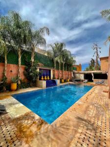 une piscine dans une cour arborée et un bâtiment dans l'établissement Villa HANIA - Ensoleillée et sans vis-à-vis, à Marrakech